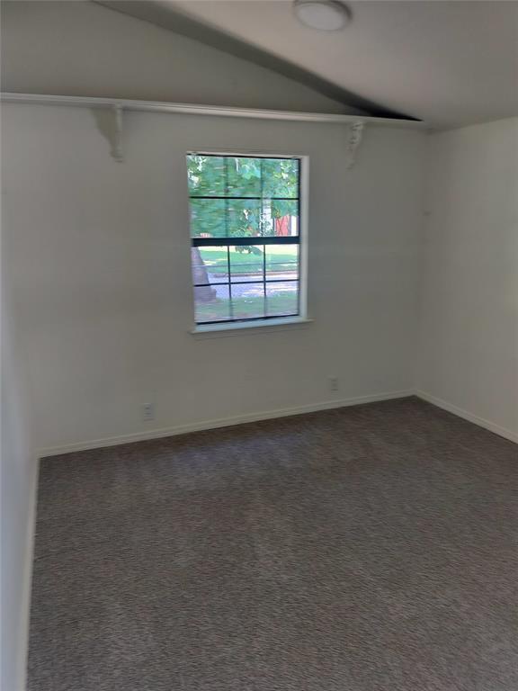 116 SE 39th St, Oklahoma City, OK 73129 - spare room with lofted ceiling and dark colored carpet