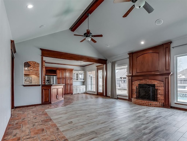 1217 Camelot Dr, Yukon, OK 73099 - unfurnished living room with a ceiling fan, beamed ceiling, a brick fireplace, recessed lighting, and high vaulted ceiling