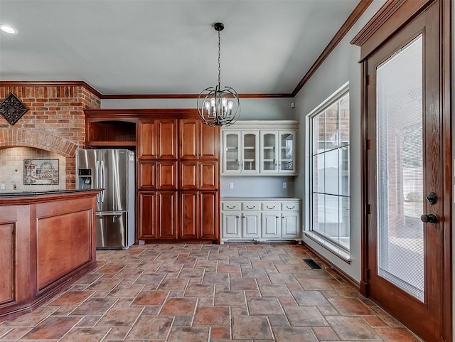 1217 Camelot Dr, Yukon, OK 73099 - kitchen featuring stone finish flooring, stainless steel fridge with ice dispenser, a chandelier, hanging light fixtures, and crown molding