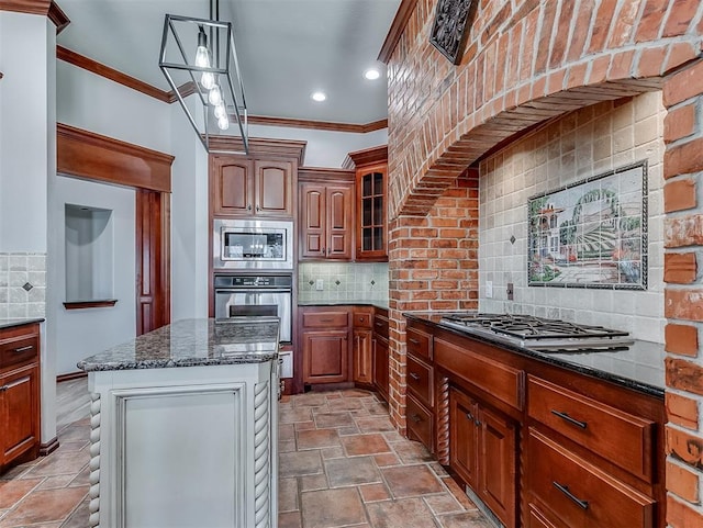 1217 Camelot Dr, Yukon, OK 73099 - kitchen featuring crown molding, appliances with stainless steel finishes, tasteful backsplash, dark stone counters, and a center island