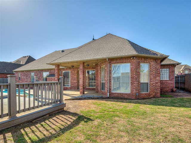 1217 Camelot Dr, Yukon, OK 73099 - rear view of property featuring a shingled roof, brick siding, and a patio