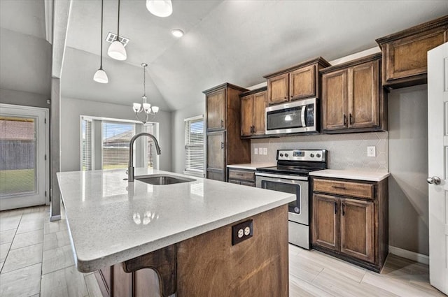 1109 Chestnut Creek Dr, Yukon, OK 73099 - kitchen with stainless steel appliances, lofted ceiling, a kitchen island with sink, tasteful backsplash, and light stone counters