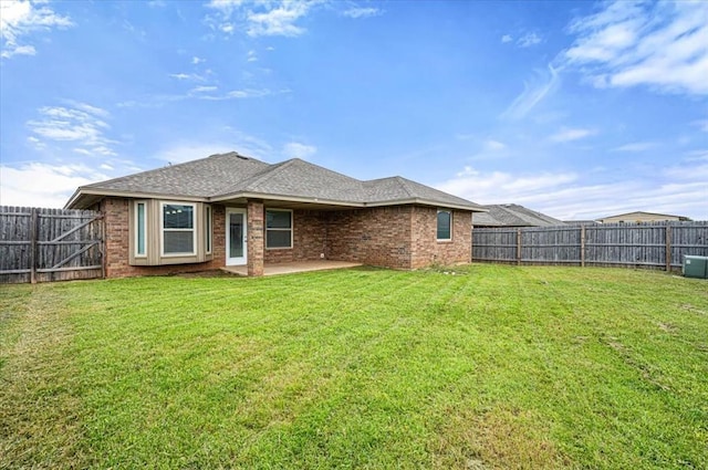 1109 Chestnut Creek Dr, Yukon, OK 73099 - back of house featuring a fenced backyard, brick siding, a patio area, and a shingled roof