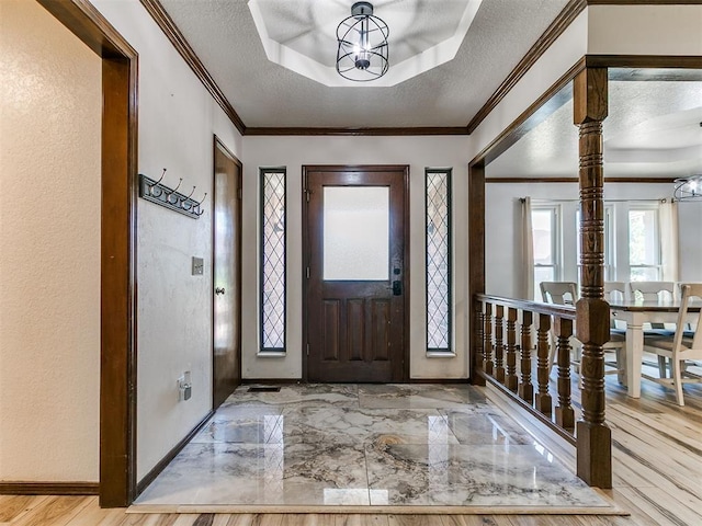 6105 W Gun Hill Way, Warr Acres, OK 73132 - entryway featuring a tray ceiling, a chandelier, crown molding, and a textured ceiling