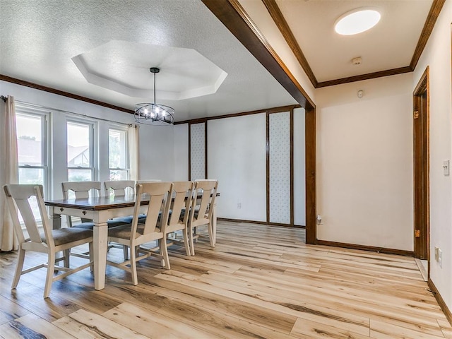 6105 W Gun Hill Way, Warr Acres, OK 73132 - dining area featuring light wood-style floors, a chandelier, ornamental molding, and a tray ceiling