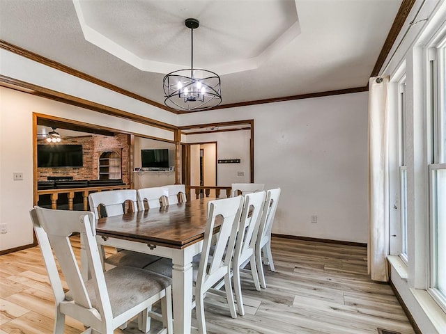6105 W Gun Hill Way, Warr Acres, OK 73132 - dining room featuring a raised ceiling, a chandelier, light wood-style floors, ornamental molding, and ceiling fan