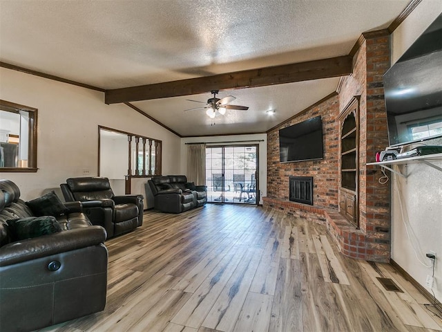 6105 W Gun Hill Way, Warr Acres, OK 73132 - living room with a textured ceiling, plenty of natural light, ceiling fan, wood finished floors, and a brick fireplace