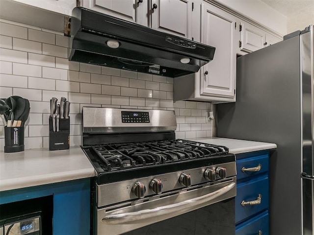 6105 W Gun Hill Way, Warr Acres, OK 73132 - kitchen featuring exhaust hood, stainless steel appliances, blue cabinetry, light countertops, and tasteful backsplash