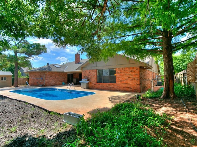 6105 W Gun Hill Way, Warr Acres, OK 73132 - view of swimming pool with a fenced backyard, area for grilling, a patio area, and an outdoor structure