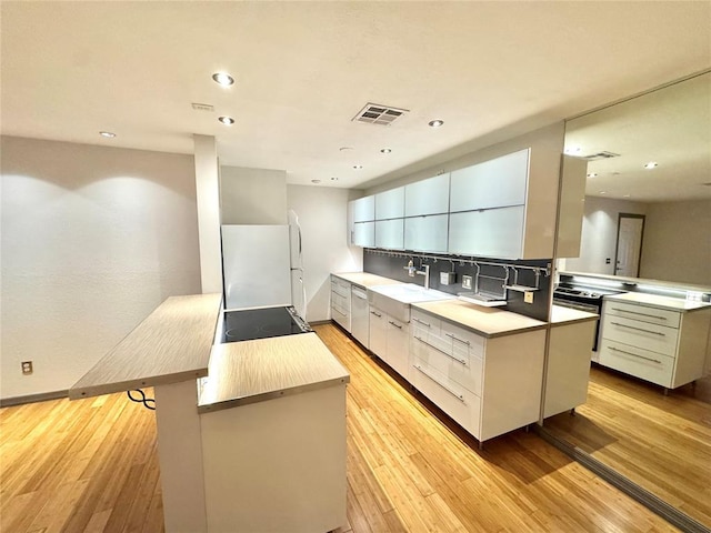 4400 Hemingway Dr Unit 202, Oklahoma City, OK 73118 - kitchen with modern cabinets, light wood-style flooring, stainless steel appliances, recessed lighting, and light countertops