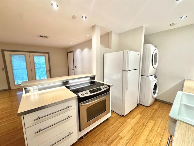 4400 Hemingway Dr Unit 202, Oklahoma City, OK 73118 - kitchen with estacked washer and dryer, freestanding refrigerator, electric range, light wood-style flooring, and recessed lighting