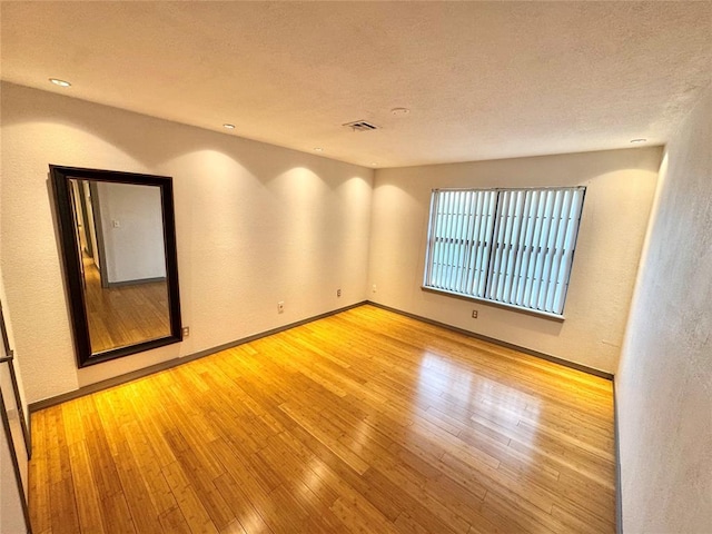 4400 Hemingway Dr Unit 202, Oklahoma City, OK 73118 - unfurnished room featuring wood finished floors, a textured wall, and a textured ceiling