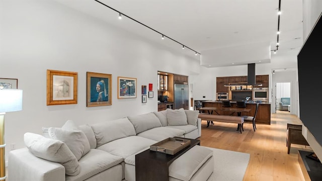 10105 SW 25th Ct, Yukon, OK 73099 - living room with rail lighting, light wood-style floors, and a towering ceiling