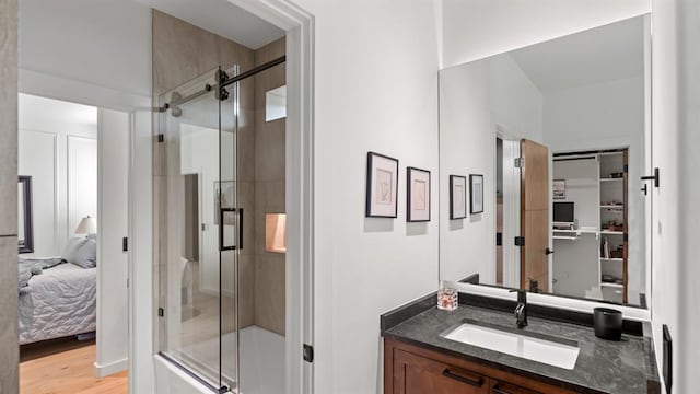 10105 SW 25th Ct, Yukon, OK 73099 - full bath with vanity, a shower stall, connected bathroom, and wood finished floors