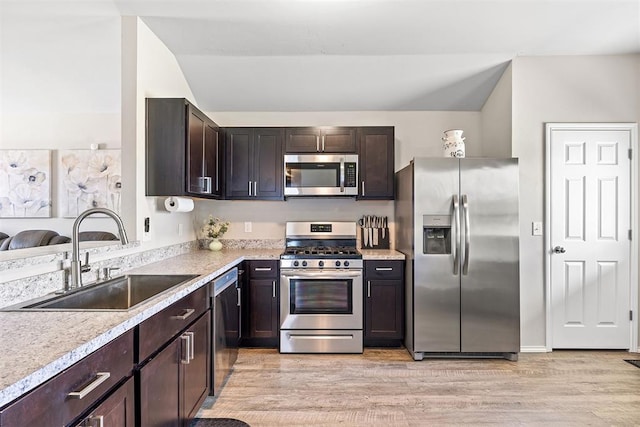 521 Audrey Dr, Tuttle, OK 73089 - kitchen with stainless steel appliances, dark brown cabinetry, light wood-type flooring, light countertops, and vaulted ceiling
