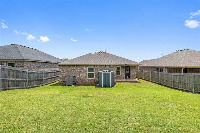 521 Audrey Dr, Tuttle, OK 73089 - rear view of house featuring brick siding, a fenced backyard, and roof with shingles