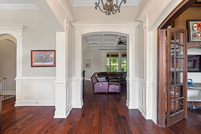 hall with dark wood-type flooring, coffered ceiling, an inviting chandelier, crown molding, and beam ceiling