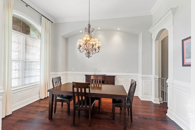 dining area with plenty of natural light, dark hardwood / wood-style floors, ornamental molding, and a chandelier