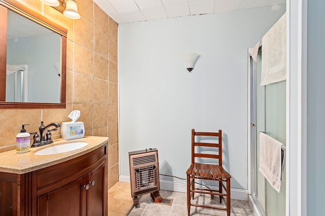 508 Newton Ave, Ozark, AL 36360 - bathroom featuring heating unit, vanity, tile walls, an enclosed shower, and tile patterned floors