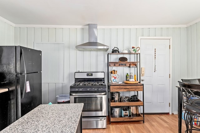 508 Newton Ave, Ozark, AL 36360 - kitchen featuring freestanding refrigerator, wall chimney exhaust hood, stainless steel range with gas stovetop, crown molding, and light wood finished floors