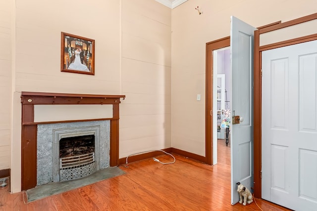 508 Newton Ave, Ozark, AL 36360 - unfurnished living room featuring wood finished floors, a fireplace with flush hearth, baseboards, and crown molding