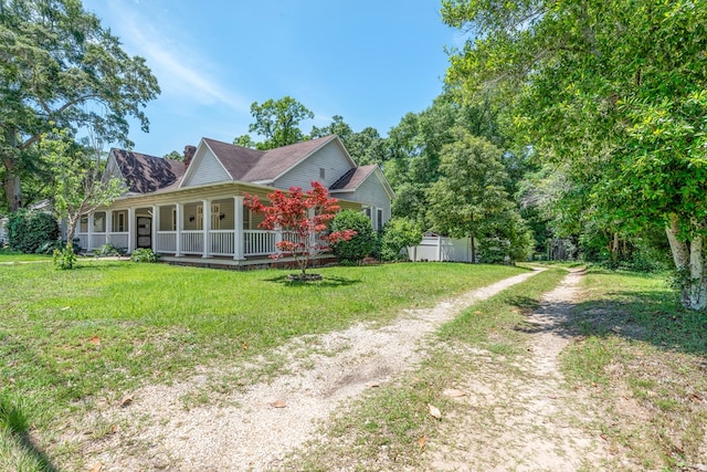 508 Newton Ave, Ozark, AL 36360 - view of side of home with driveway, covered porch, a chimney, and a lawn