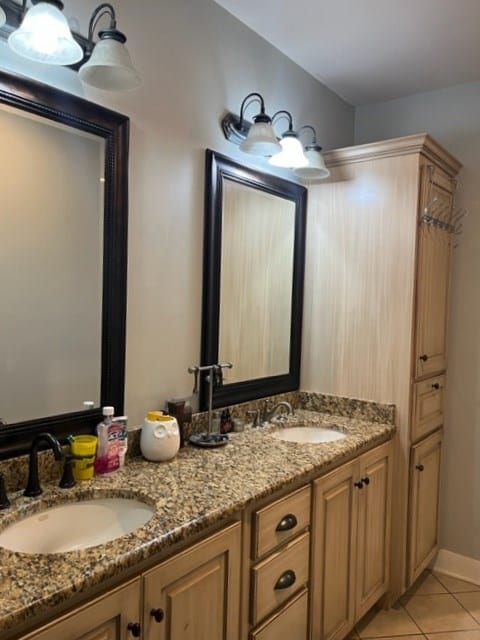 bathroom featuring tile patterned flooring, a sink, and double vanity