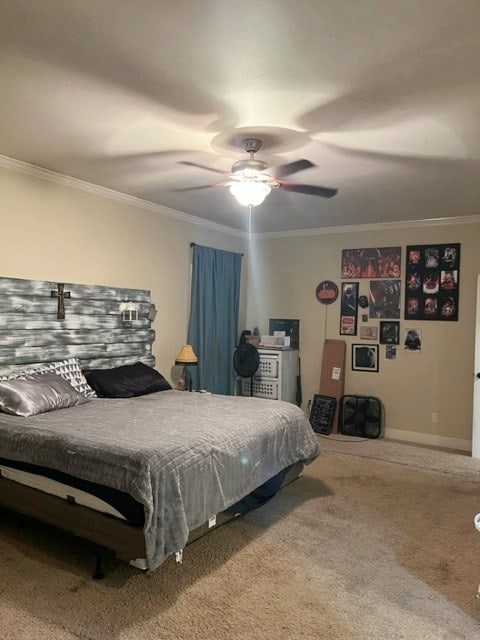 carpeted bedroom featuring ceiling fan, baseboards, and crown molding