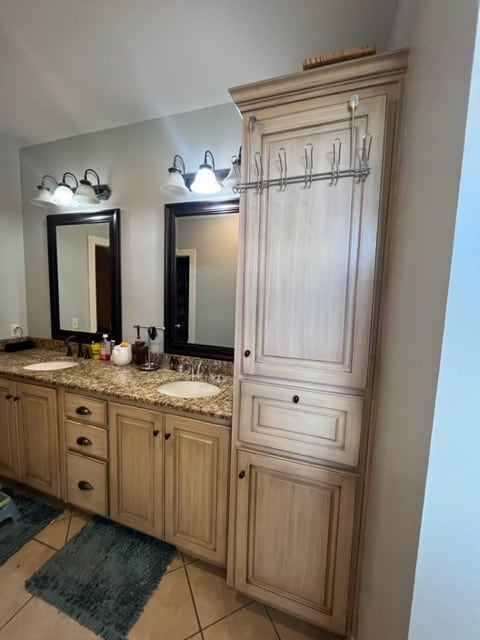 bathroom with double vanity, tile patterned flooring, and a sink