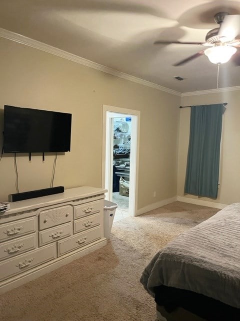 bedroom featuring crown molding, visible vents, a ceiling fan, carpet flooring, and baseboards