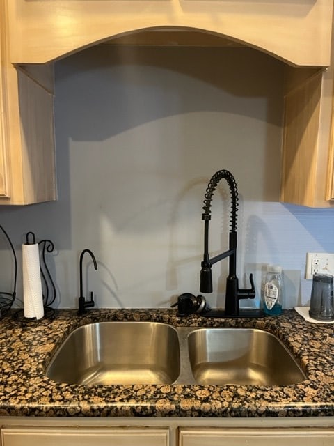 room details featuring dark stone countertops and a sink