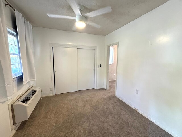 2403 Stonebridge Rd, Dothan, AL 36301 - unfurnished bedroom with carpet floors, an AC wall unit, a closet, a textured ceiling, and baseboards