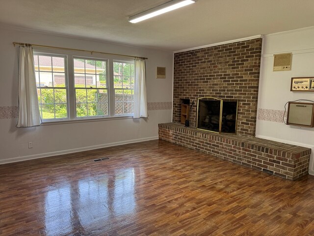 2403 Stonebridge Rd, Dothan, AL 36301 - unfurnished living room with wood finished floors, a brick fireplace, and ornamental molding