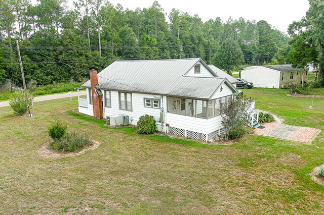 view of front of home with a sunroom and a front lawn