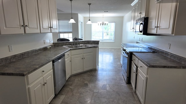 kitchen featuring a notable chandelier, dark countertops, appliances with stainless steel finishes, and a sink