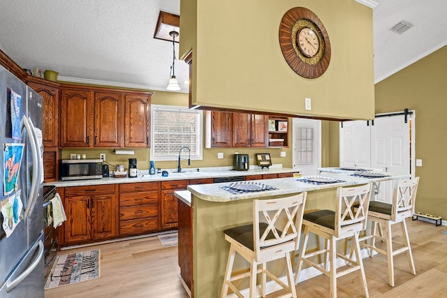 kitchen with light countertops, a kitchen island, a kitchen bar, and stainless steel appliances