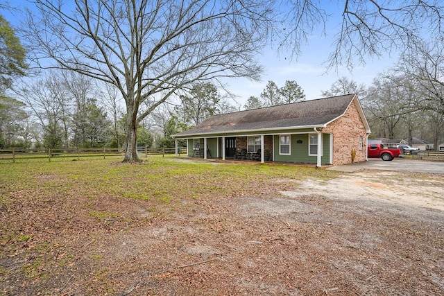 exterior space with driveway, fence, and a porch