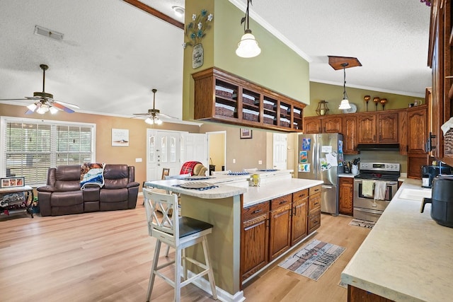 kitchen featuring under cabinet range hood, open floor plan, light countertops, appliances with stainless steel finishes, and a center island