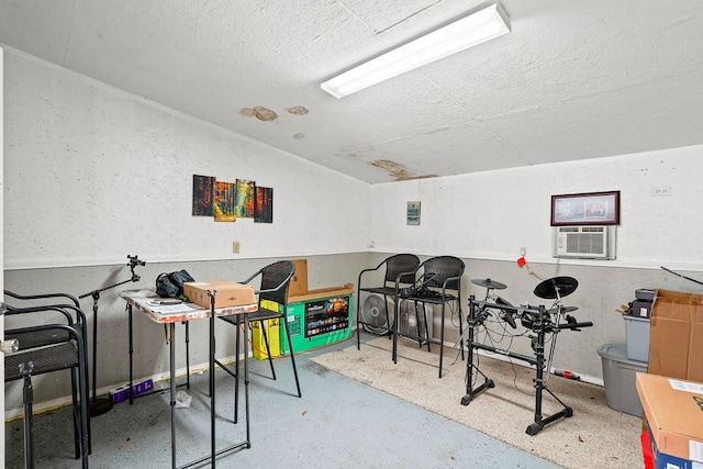 game room featuring lofted ceiling, cooling unit, and a textured ceiling