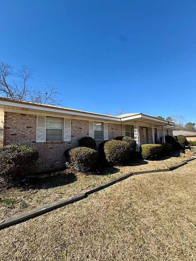 view of side of home with a yard