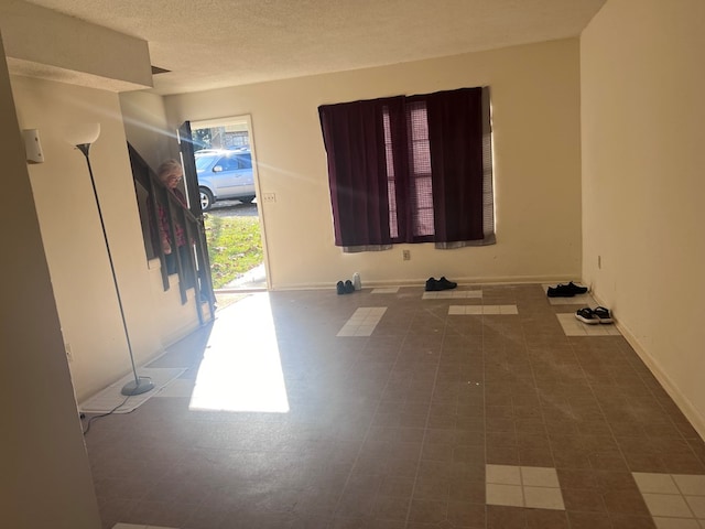 empty room featuring tile patterned flooring and a textured ceiling