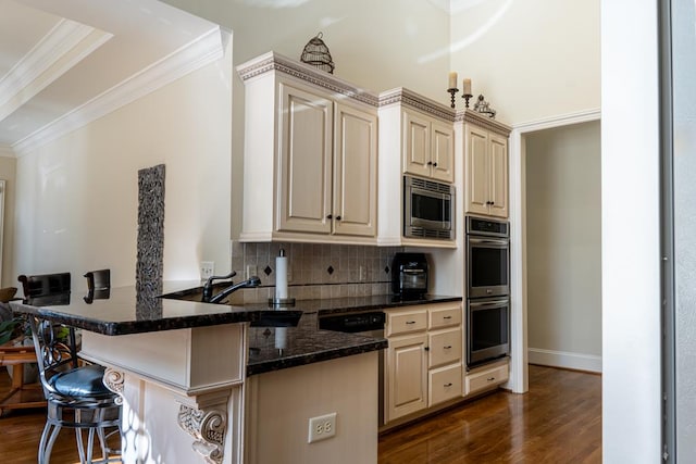 kitchen featuring a kitchen breakfast bar, dark hardwood / wood-style floors, kitchen peninsula, dark stone countertops, and appliances with stainless steel finishes