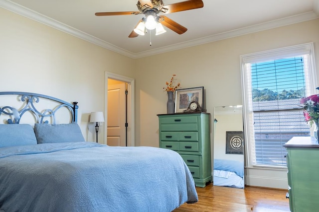 bedroom with light wood-type flooring, ceiling fan, and crown molding