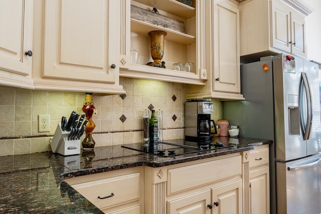 kitchen featuring stainless steel fridge with ice dispenser, dark stone countertops, and decorative backsplash