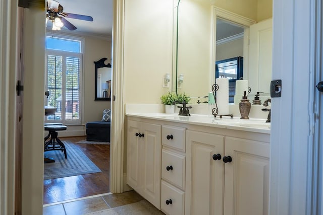 bathroom featuring ceiling fan, vanity, wood-type flooring, and ornamental molding