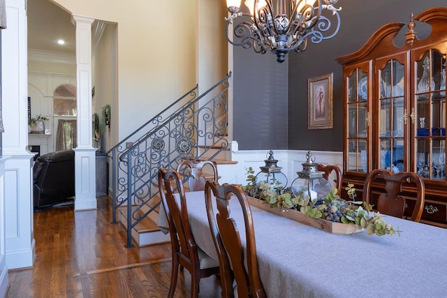 dining area with a chandelier, dark hardwood / wood-style flooring, ornate columns, and ornamental molding