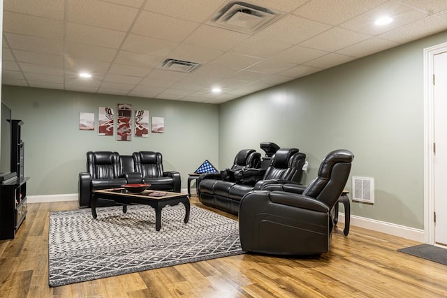 cinema room with hardwood / wood-style floors and a paneled ceiling