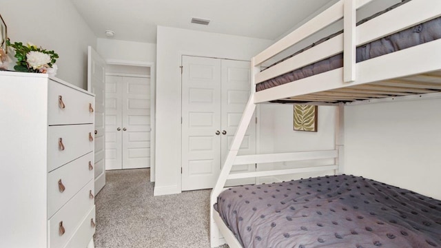 carpeted bedroom with a closet and visible vents