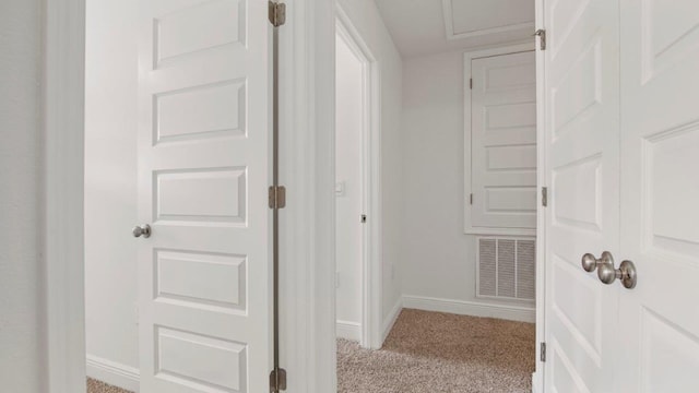 hall featuring light colored carpet, baseboards, and visible vents