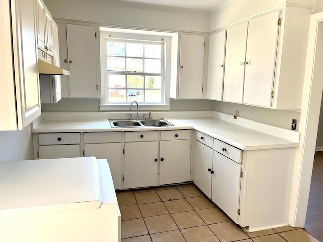 kitchen with sink, white cabinets, and light tile patterned flooring